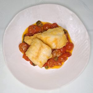 Merluza a la romana con tomatitos.